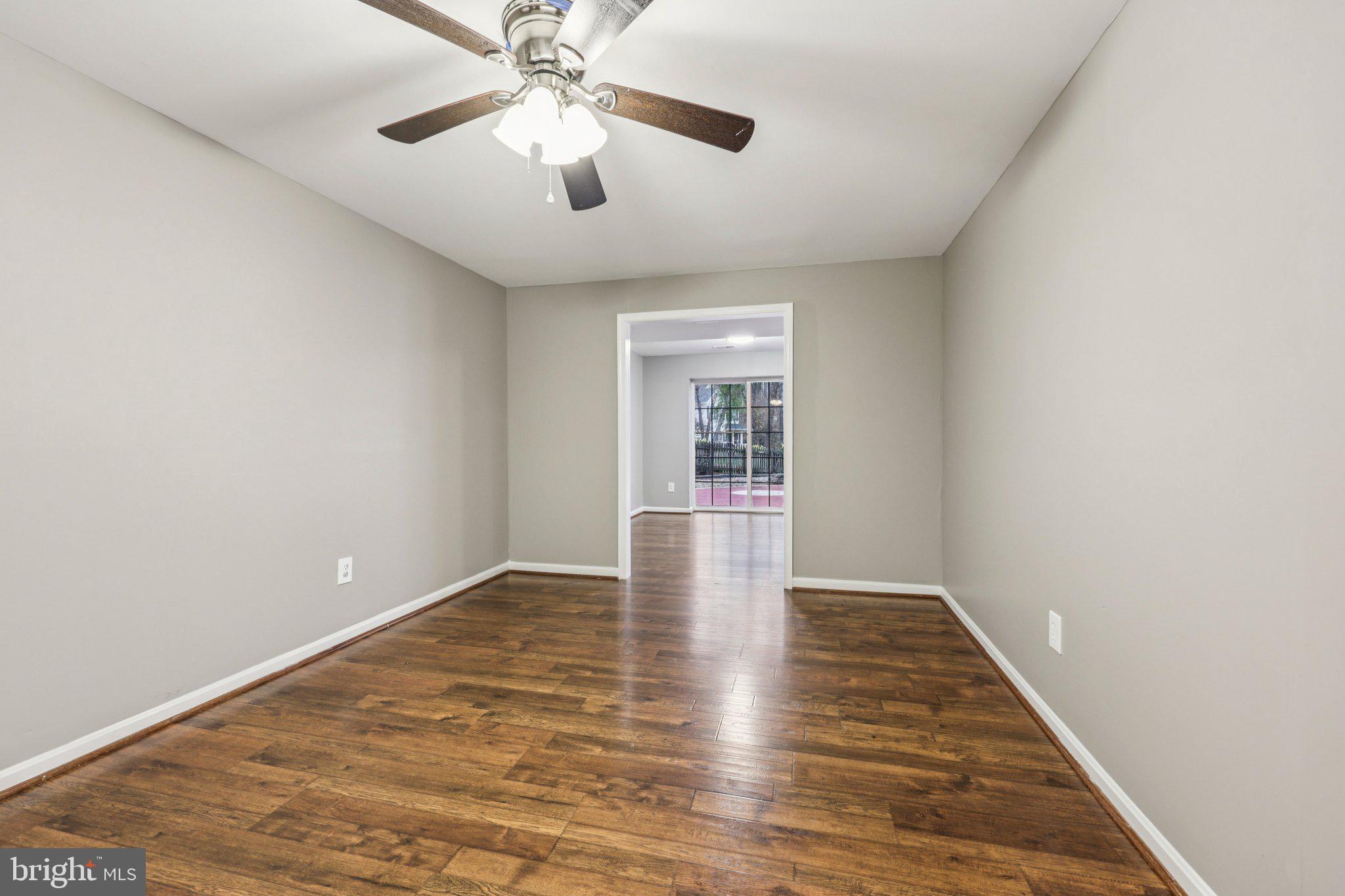 15730 Marbury Heights Way Montclair, VA 22025 - Photo 25 of 69 an empty room with wooden floor chandelier fan and windows
