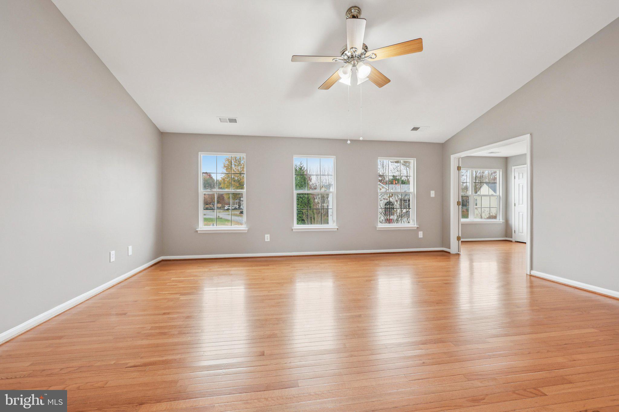 15730 Marbury Heights Way Montclair, VA 22025 - Photo 46 of 69 an empty room with wooden floor chandelier fan and windows