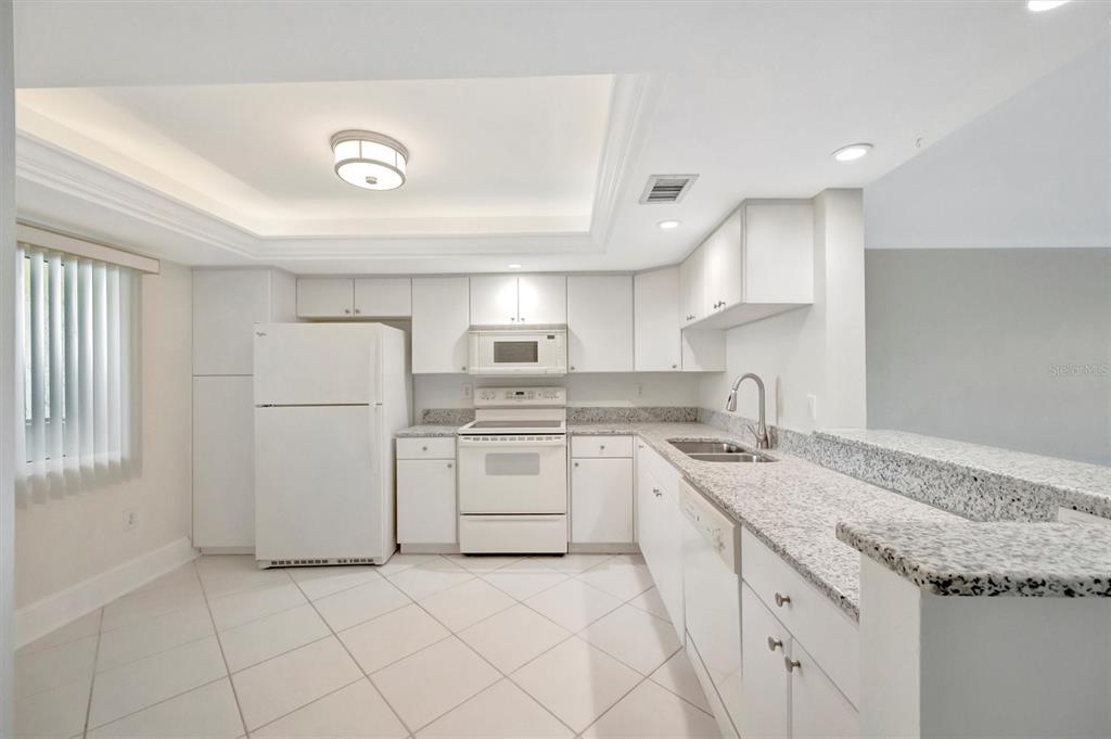 9604 Cortez Road West, Unit 222 Bradenton, FL 34210 - Photo 12 of 54 a kitchen with white cabinets and white appliances