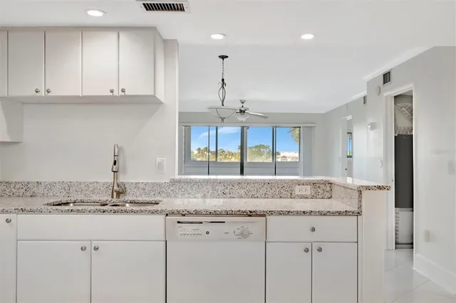a view of a kitchen with refrigerator and windows