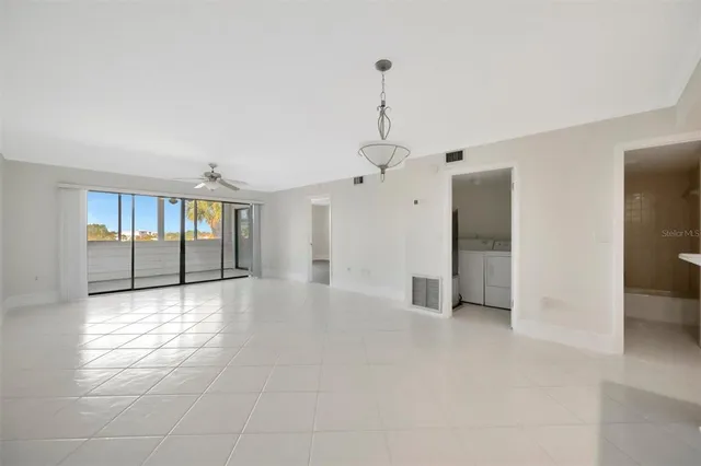 a view of empty room with wooden floor and ceiling fan