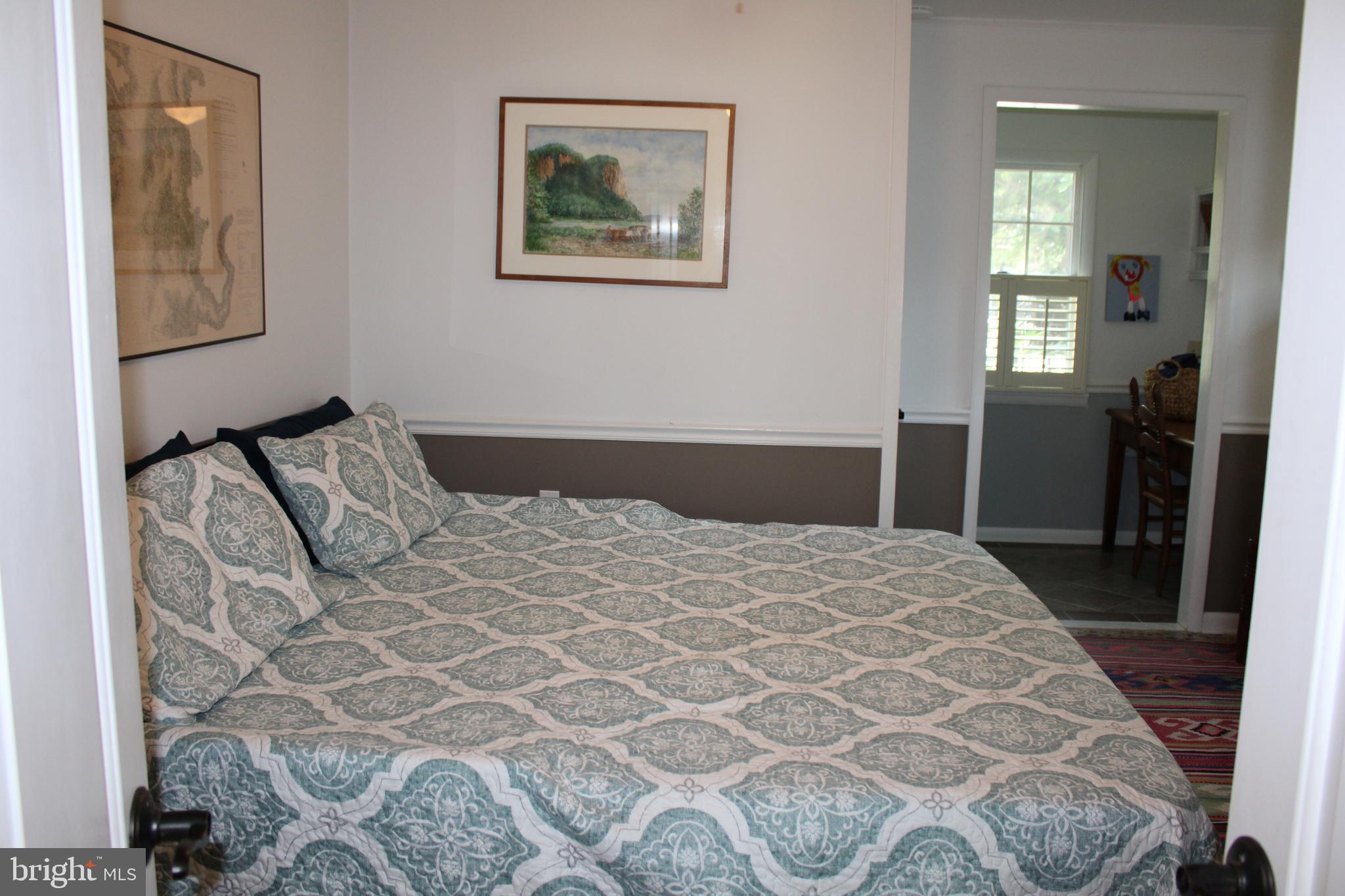 6050 Sunset Lane Tilghman, MD 21671 - Photo 34 of 74 a bedroom with a bed and a painting on the wall