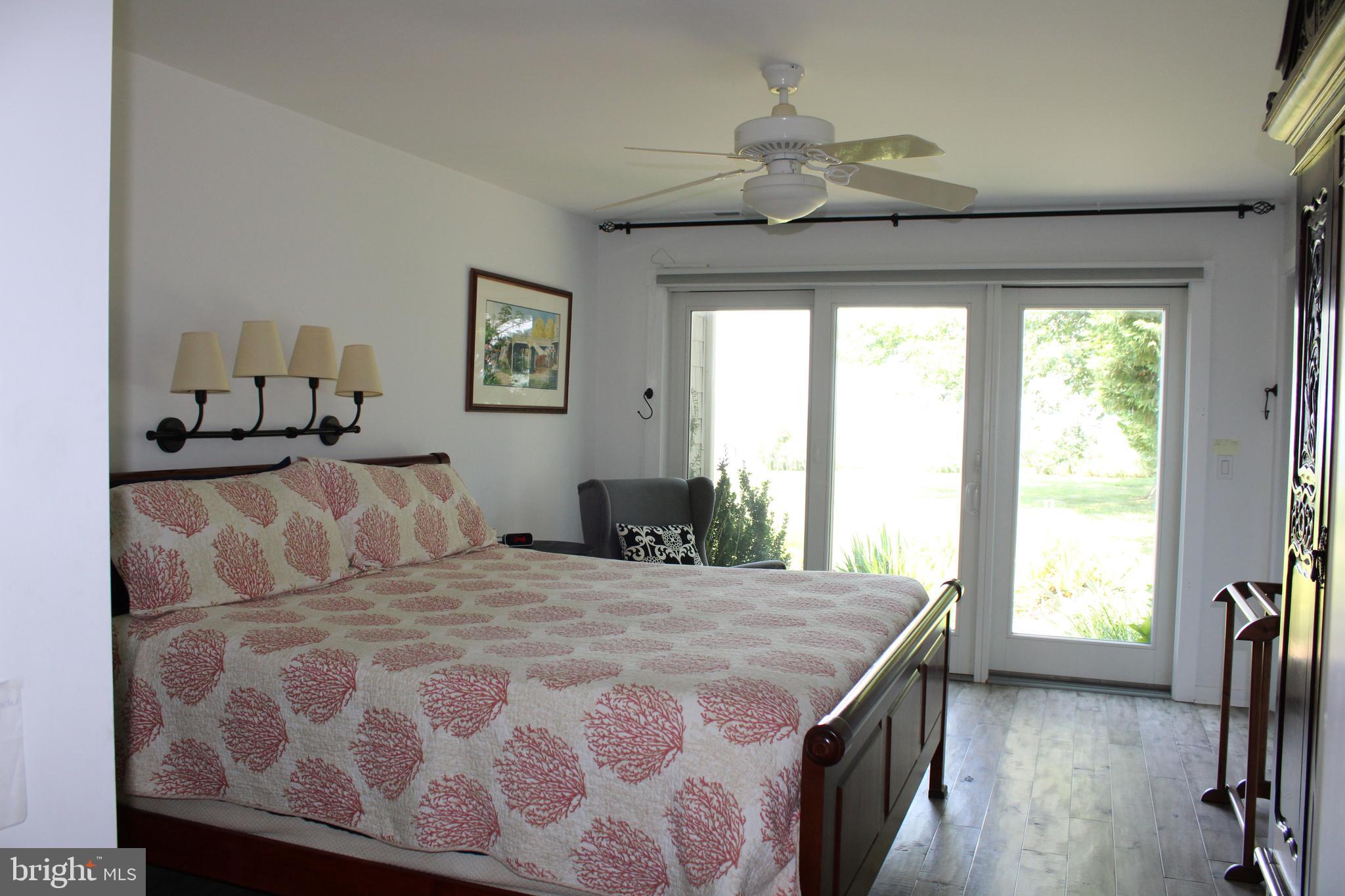 6050 Sunset Lane Tilghman, MD 21671 - Photo 40 of 74 a bedroom with a large bed and a chandelier