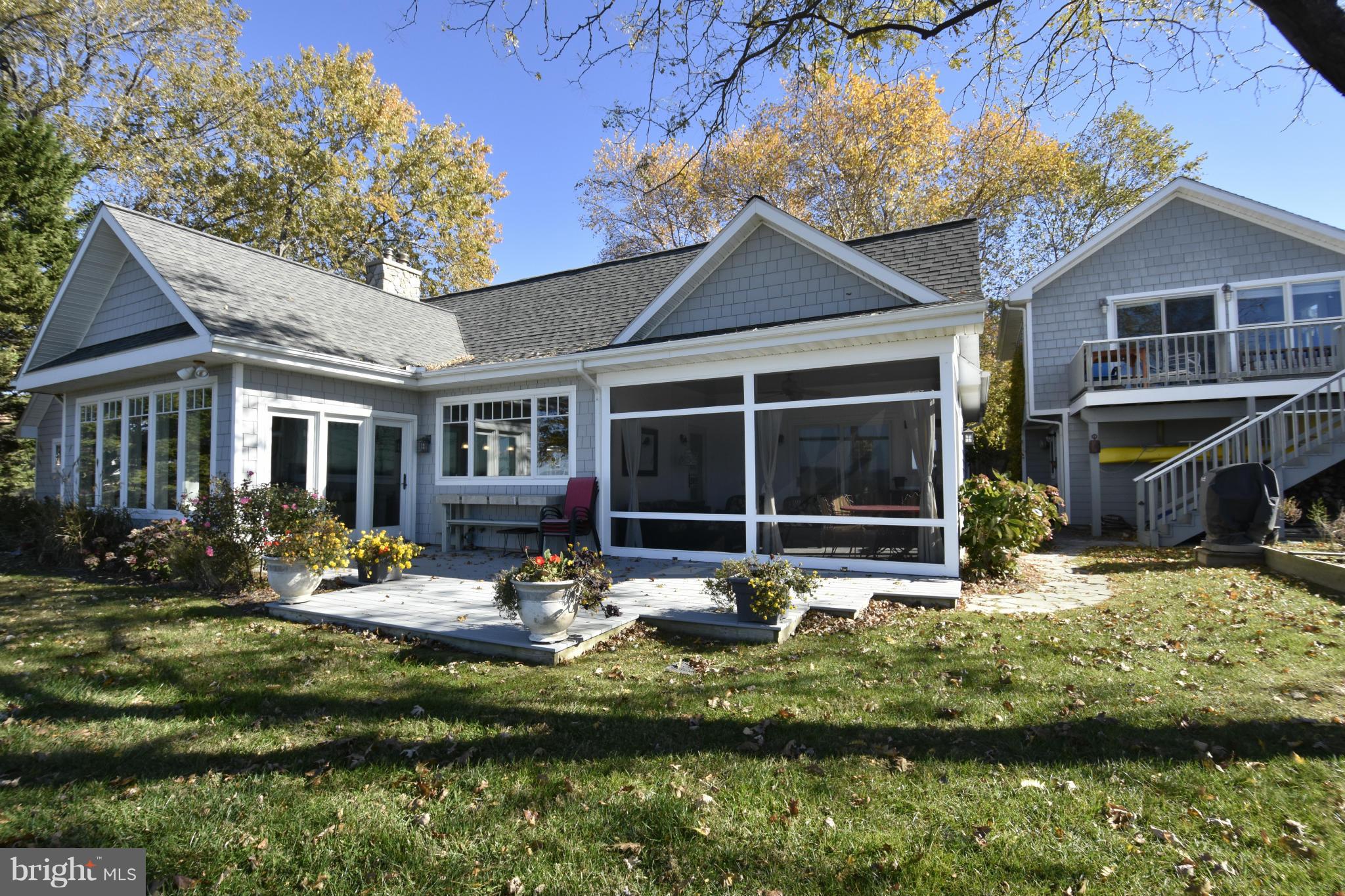 6050 Sunset Lane Tilghman, MD 21671 - Photo 4 of 74 a front view of a house with a yard fire pit and outdoor seating