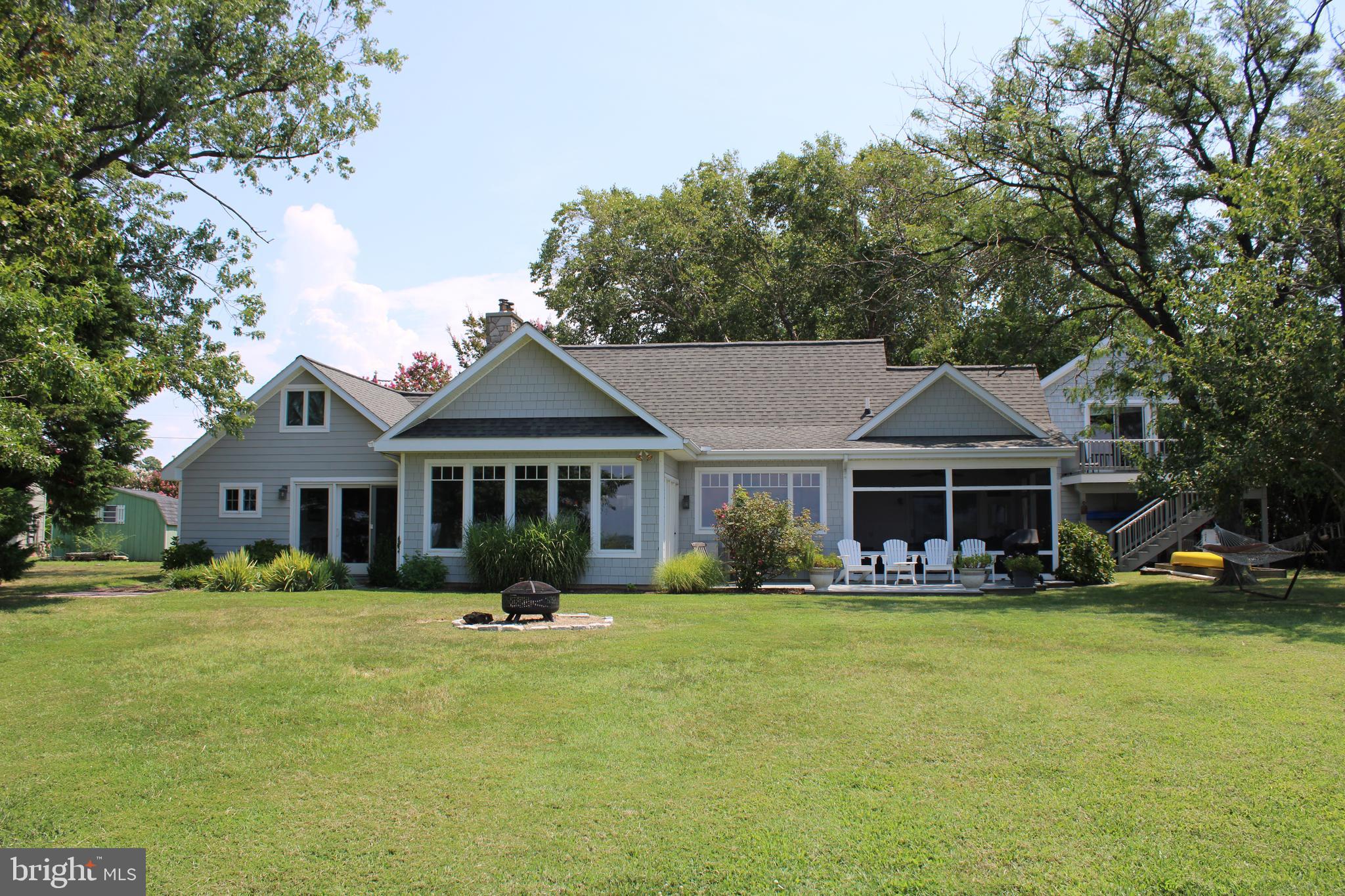 6050 Sunset Lane Tilghman, MD 21671 - Photo 61 of 74 a front view of a house with a garden and trees