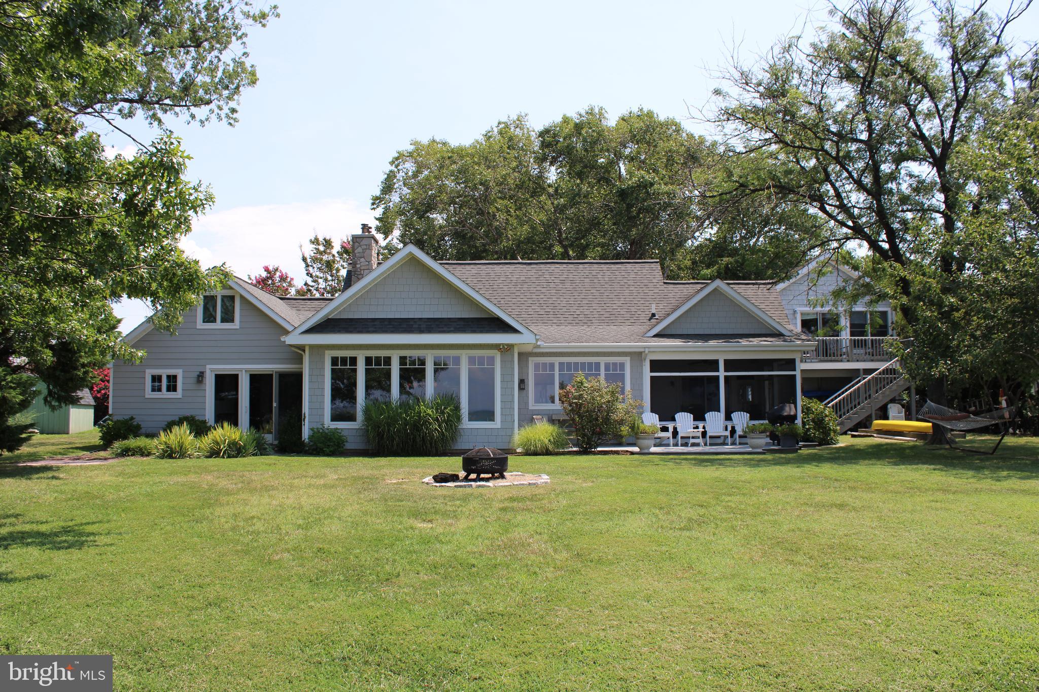 6050 Sunset Lane Tilghman, MD 21671 - Photo 62 of 74 a front view of a house with a yard table and chairs