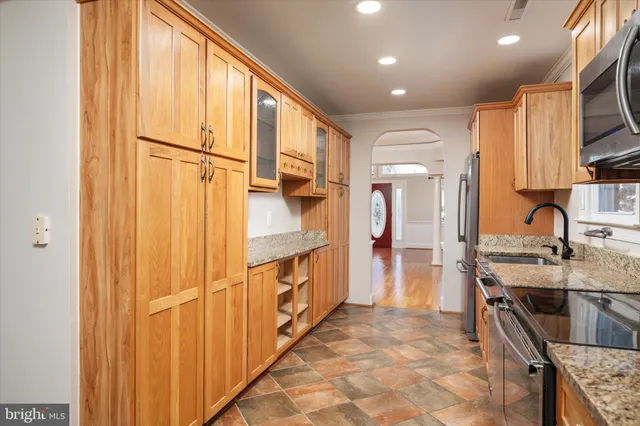 a kitchen with stainless steel appliances granite countertop a refrigerator and a stove top oven