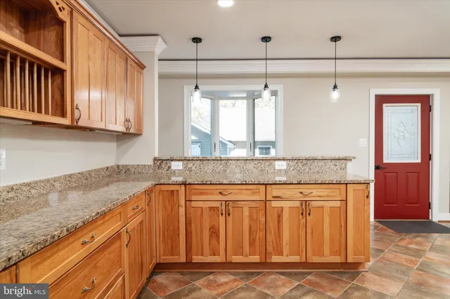 an empty room with wooden floor fireplace and windows