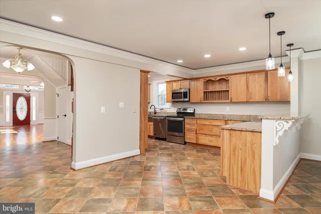 a view of an empty room with wooden floor and a fireplace