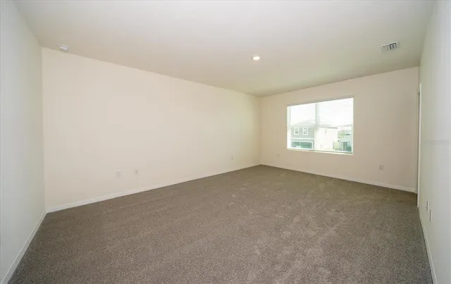 an empty room with a window and a hallway