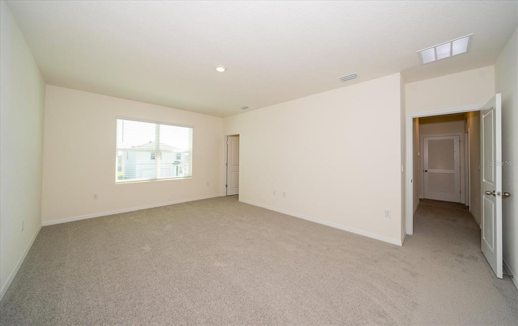 31127 Penny Surf Loop Wesley Chapel, FL 33545 - Photo 19 of 33 an empty room with a window and a hallway