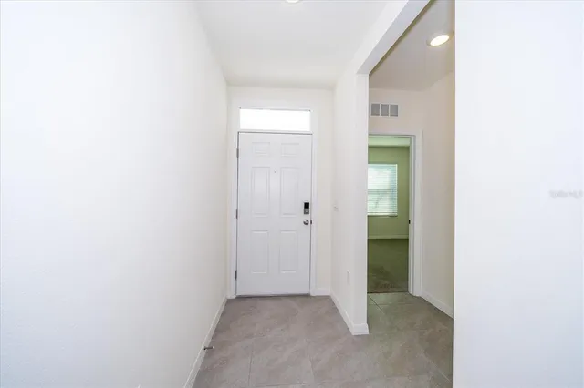 a view of an empty room with closet and a bathroom