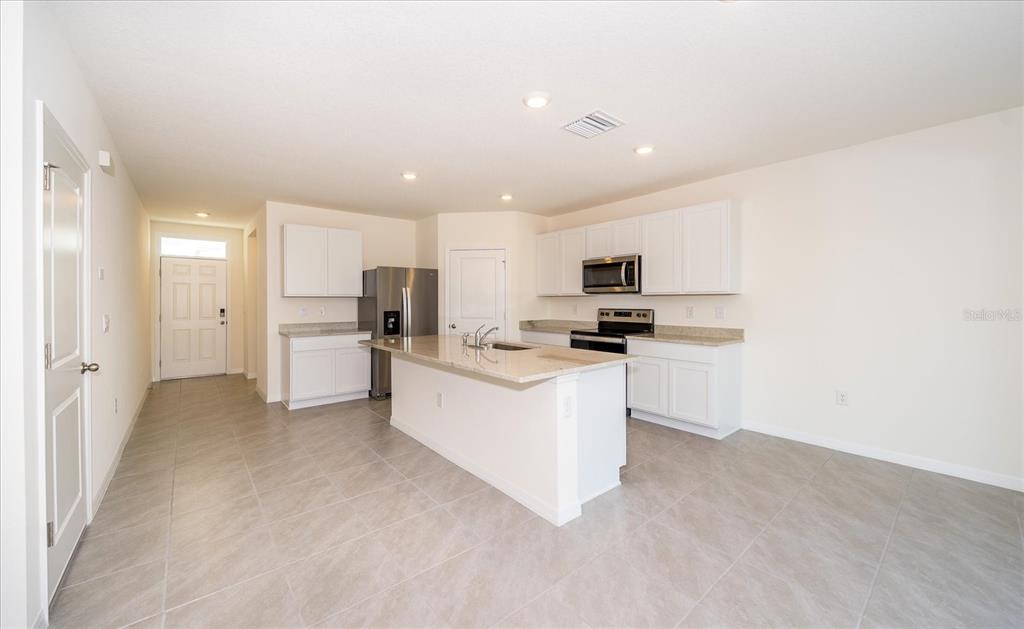 31127 Penny Surf Loop Wesley Chapel, FL 33545 - Photo 10 of 33 a kitchen with white cabinets and white appliances