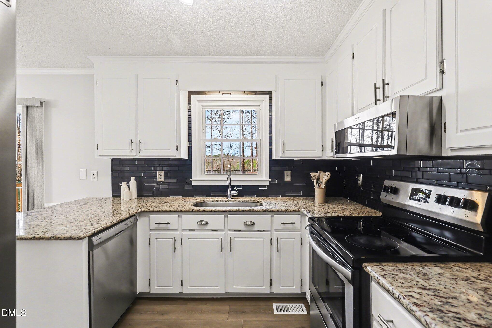 2020 Spring Valley Drive Clayton, NC 27520 - Photo 9 of 32 a kitchen with stainless steel appliances granite countertop a stove sink and cabinets