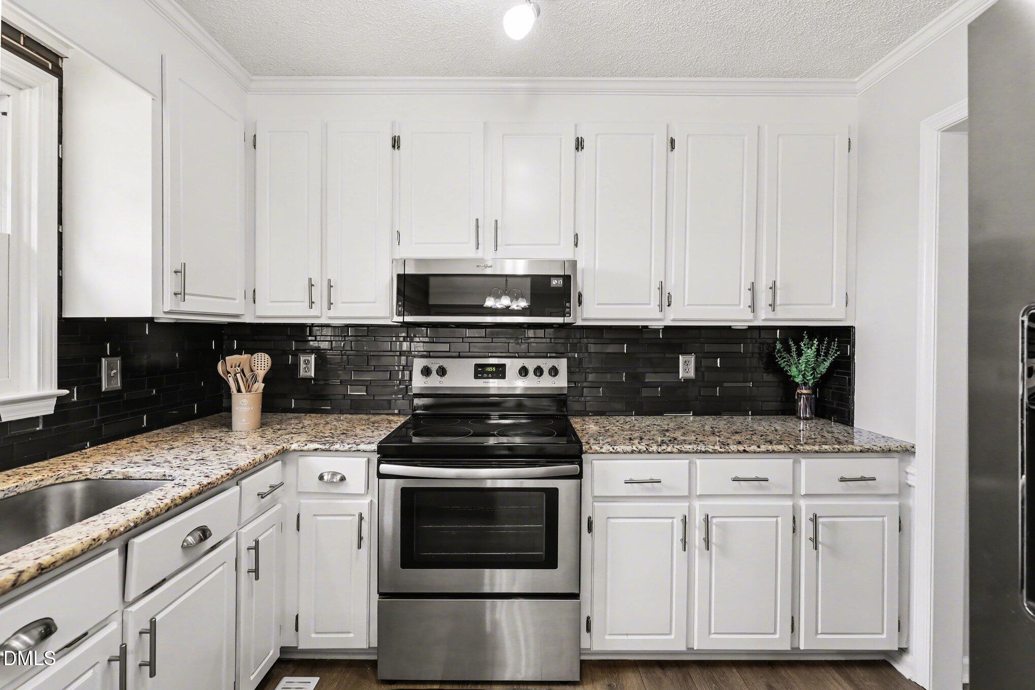 2020 Spring Valley Drive Clayton, NC 27520 - Photo 10 of 32 a kitchen with stainless steel appliances granite countertop a stove a sink and white cabinets