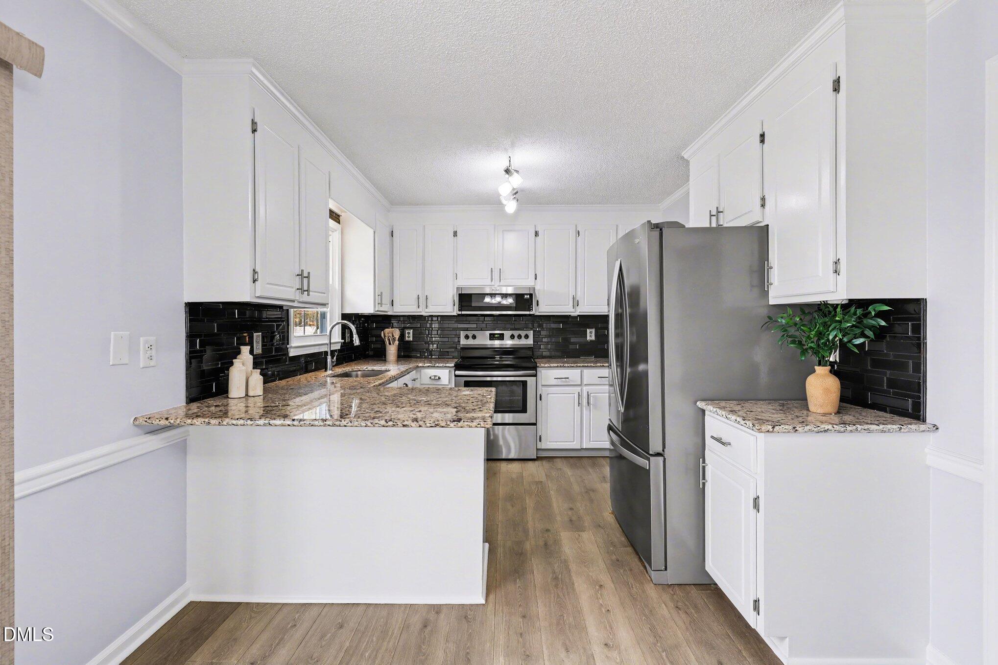 2020 Spring Valley Drive Clayton, NC 27520 - Photo 11 of 32 a kitchen with a refrigerator a stove a sink a microwave and cabinets