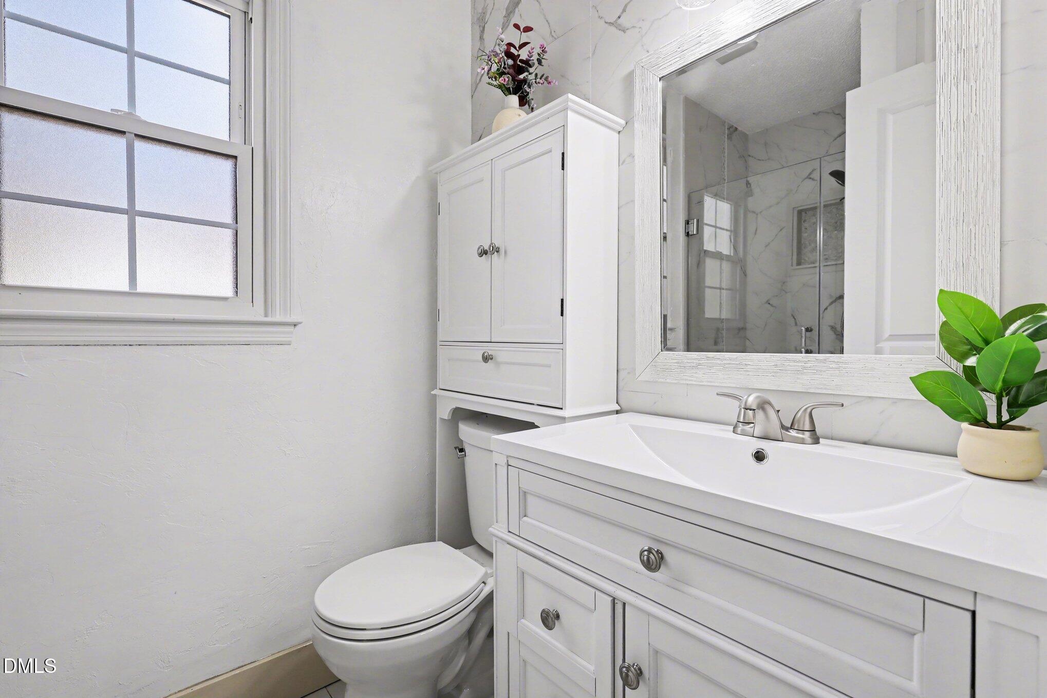 2020 Spring Valley Drive Clayton, NC 27520 - Photo 15 of 32 a bathroom with a sink a toilet and a mirror