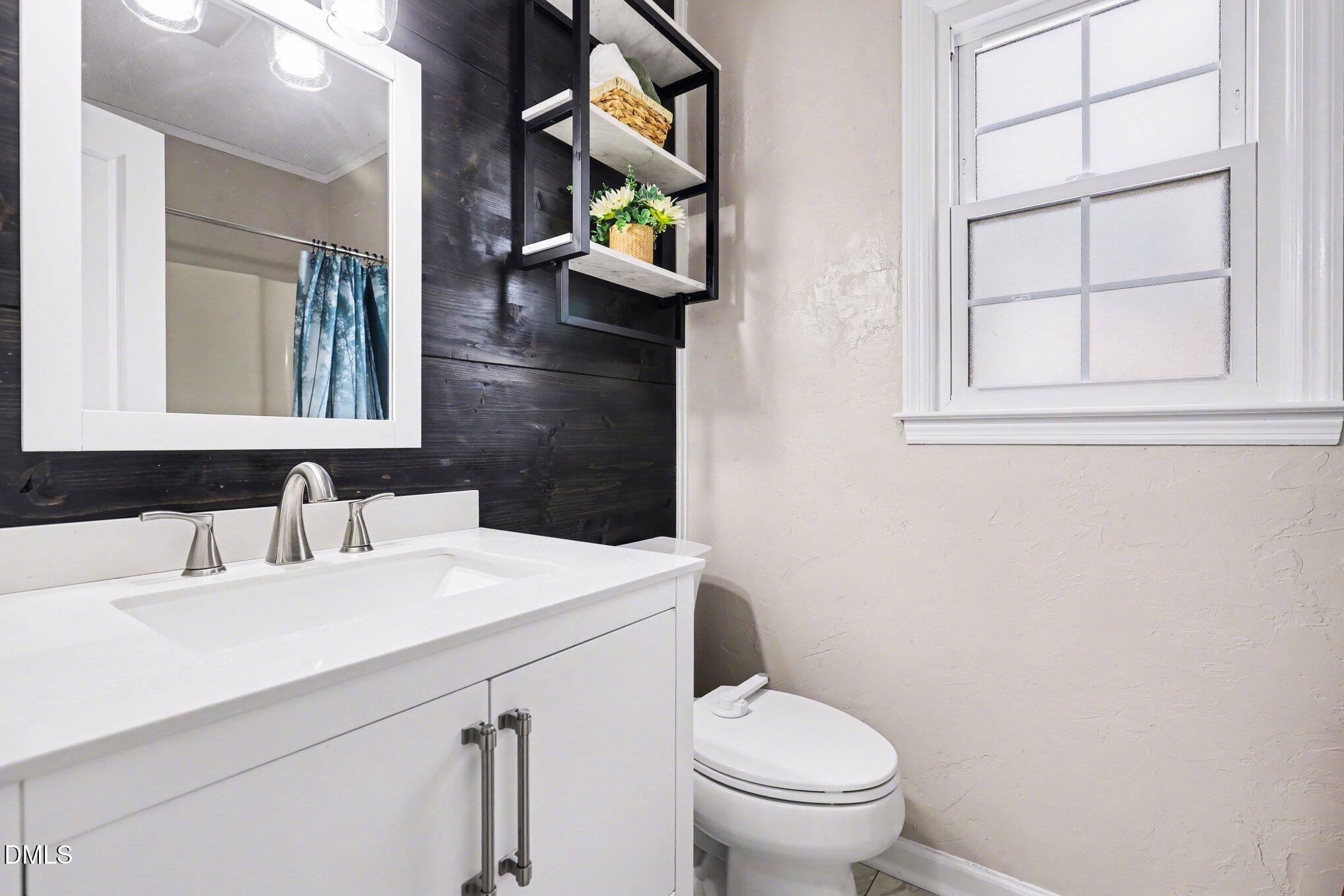 2020 Spring Valley Drive Clayton, NC 27520 - Photo 18 of 32 a bathroom with a sink a toilet and a mirror