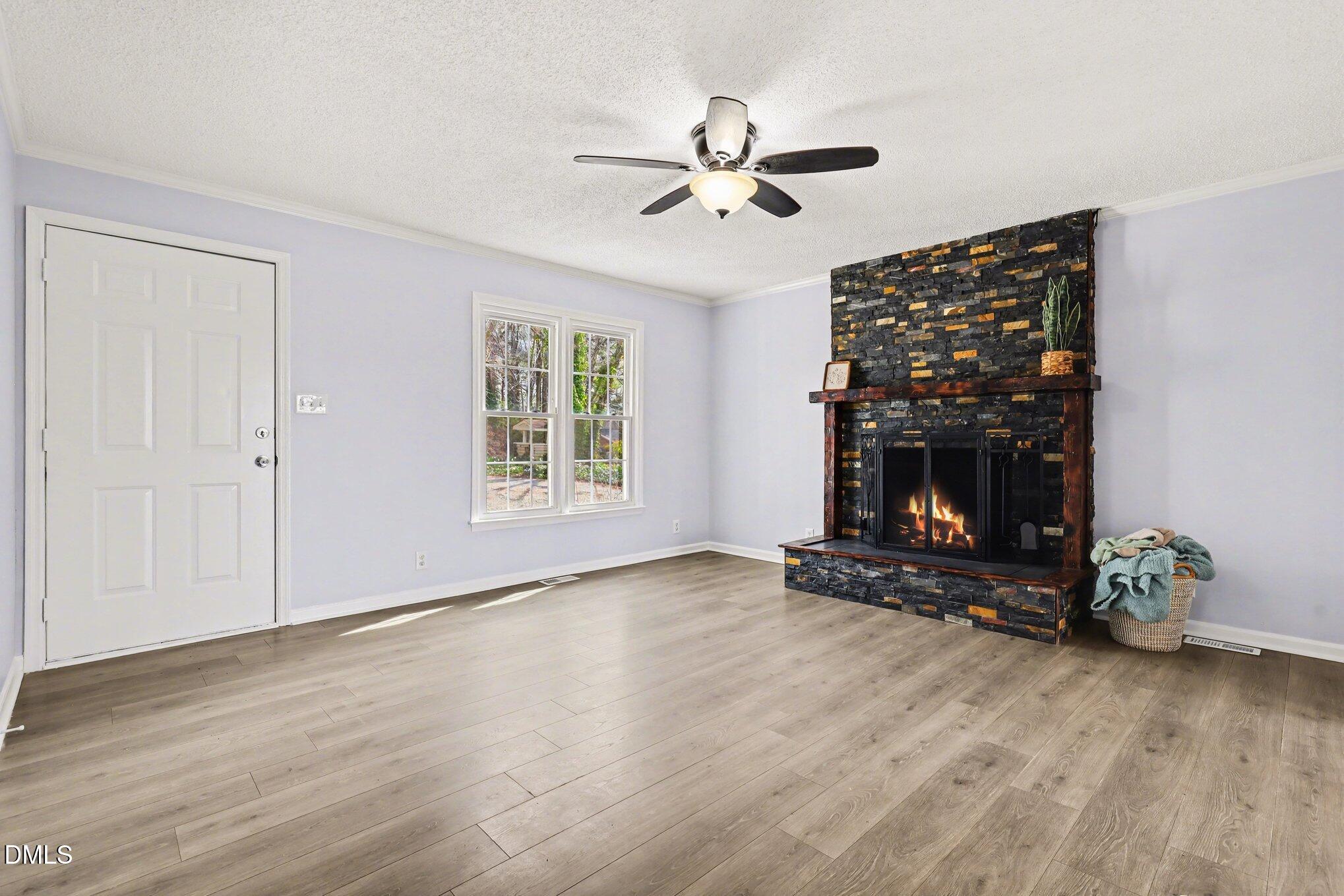 2020 Spring Valley Drive Clayton, NC 27520 - Photo 7 of 32 a view of an empty room with wooden floor fireplace and a window