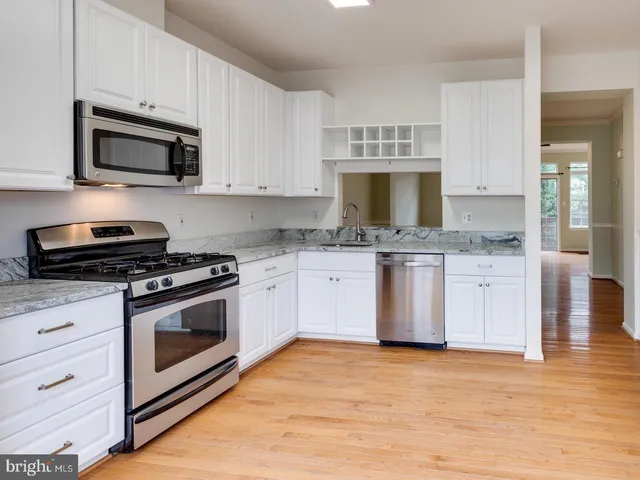 a kitchen with stainless steel appliances granite countertop a sink stove and microwave