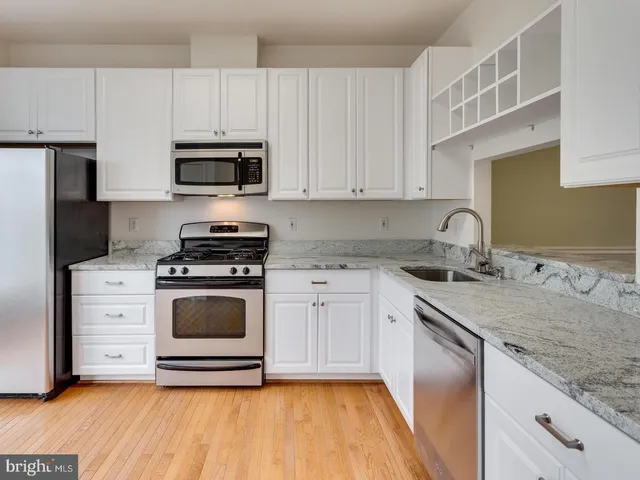 a kitchen with stainless steel appliances granite countertop a sink and cabinets