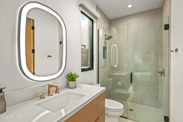 a bathroom with a granite countertop sink a toilet and a mirror