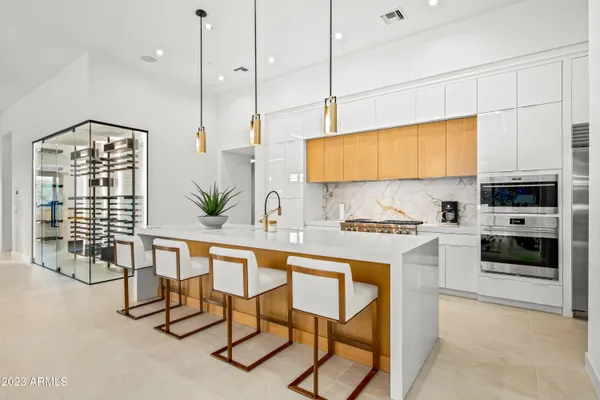 a kitchen with stainless steel appliances kitchen island granite countertop a stove a sink and a refrigerator with wooden floor