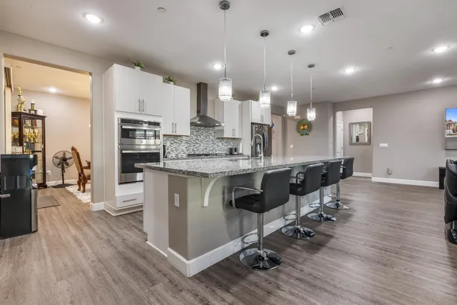 a large kitchen with stainless steel appliances granite countertop a sink stove and cabinets