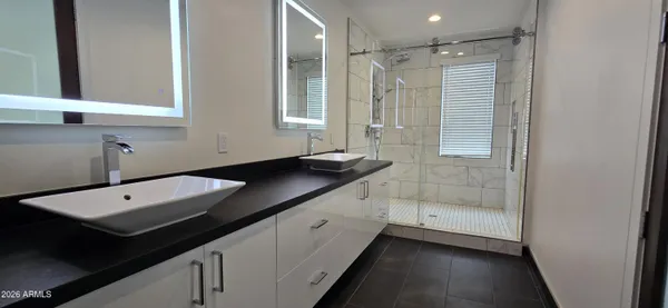 a bathroom with a double vanity sink a mirror and a bathtub