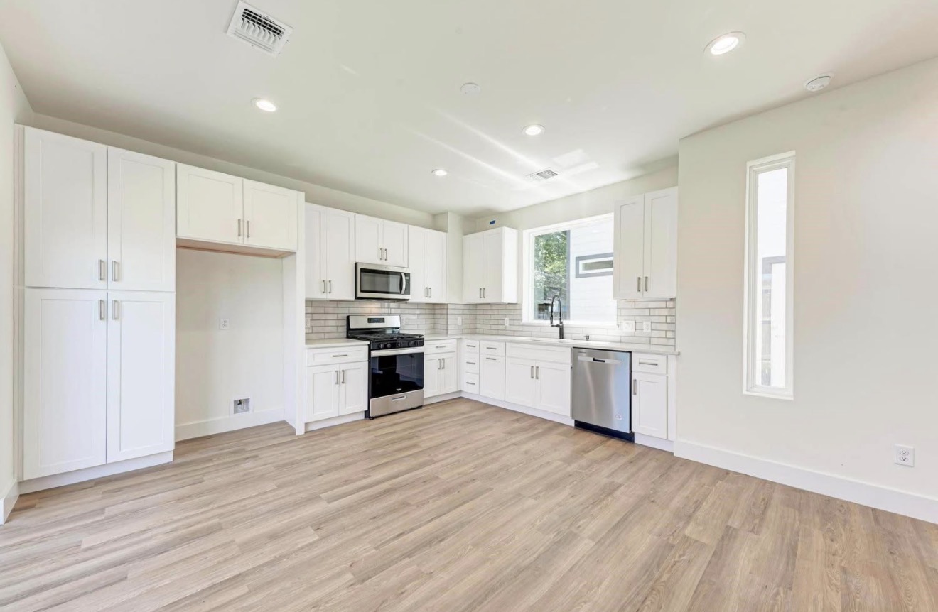 502 Tillery Street, Unit 2 Austin, TX 78702 - Photo 4 of 15 a kitchen with white cabinets and stainless steel appliances