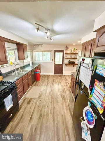 a large kitchen with stainless steel appliances granite countertop a stove and wooden floor