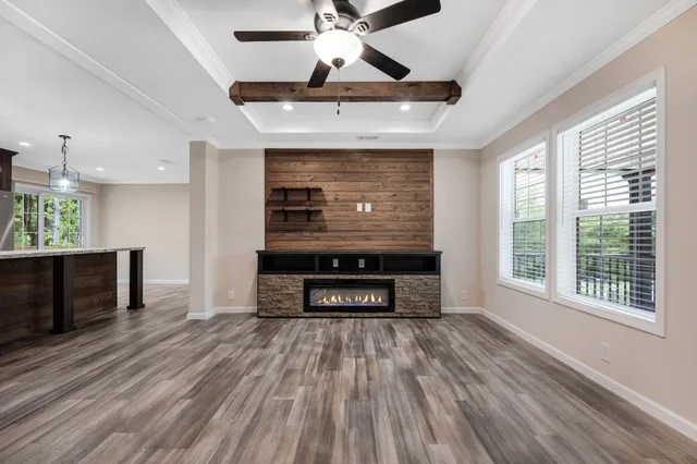 a living room with stainless steel appliances granite countertop furniture a fireplace and a flat screen tv
