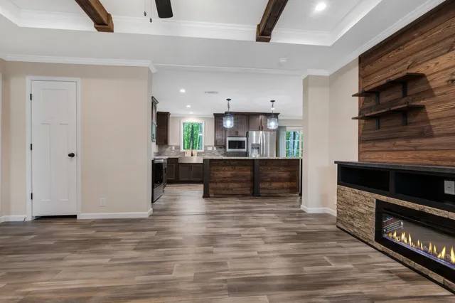 a large kitchen with stainless steel appliances a large counter top a stove and a refrigerator