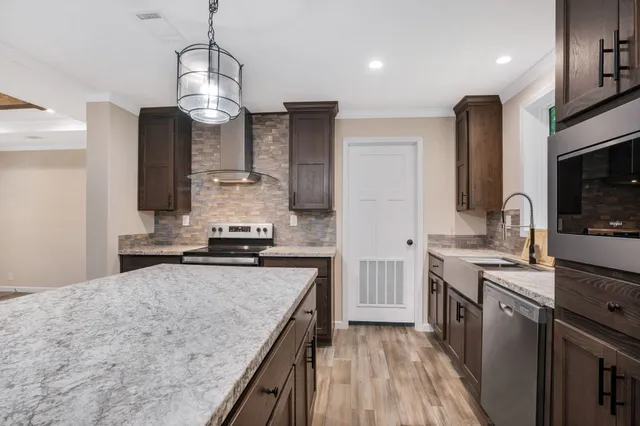 a kitchen with stainless steel appliances granite countertop a sink stove and refrigerator