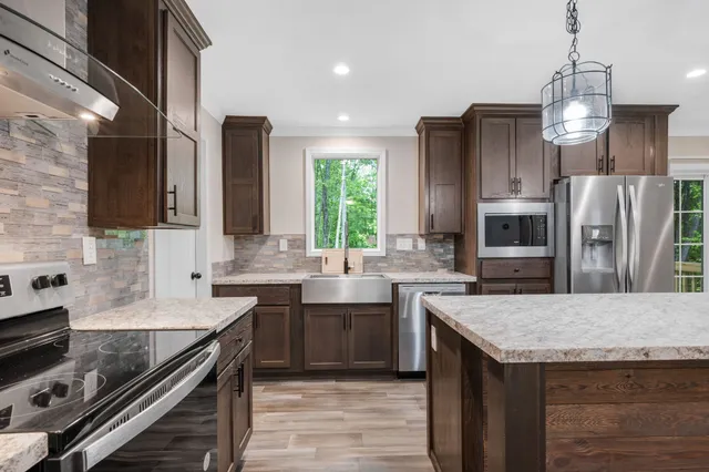 a kitchen with stainless steel appliances granite countertop a sink stove and refrigerator