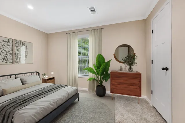 a bedroom with bed and a potted plant