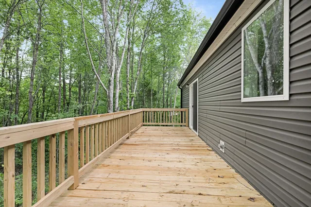 a view of a wooden balcony and trees