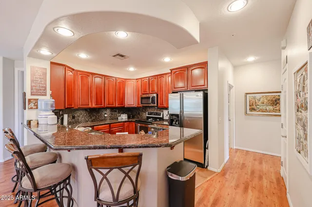 a kitchen with stainless steel appliances granite countertop a sink and refrigerator