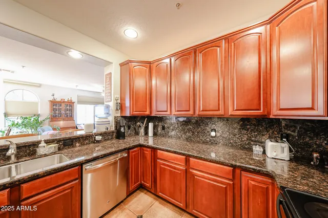 a kitchen with stainless steel appliances granite countertop a sink a stove cabinets and a counter top space