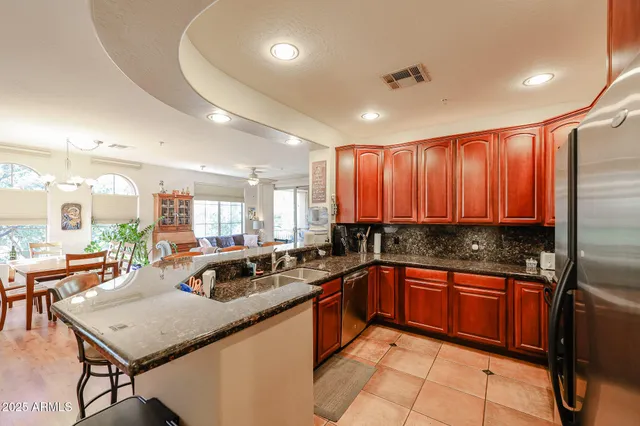 a kitchen with a sink a counter and chairs