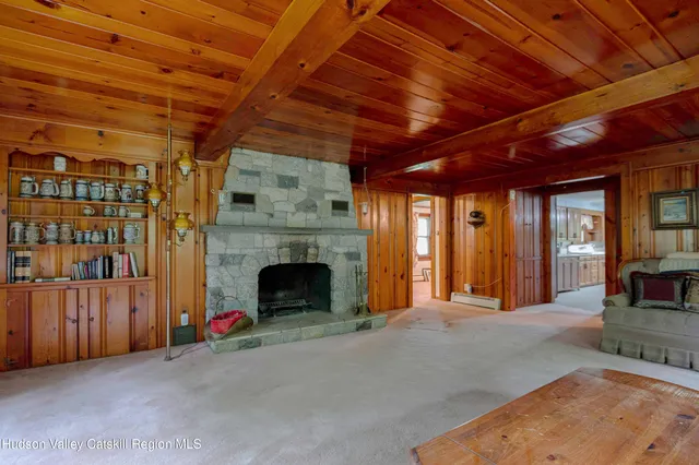 a view of an empty room with fireplace and a window