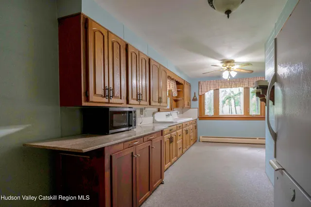 a kitchen with stainless steel appliances a sink dishwasher a stove and a refrigerator with wooden floor