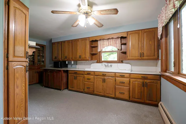 a kitchen with granite countertop wooden cabinets stainless steel appliances a window and a sink