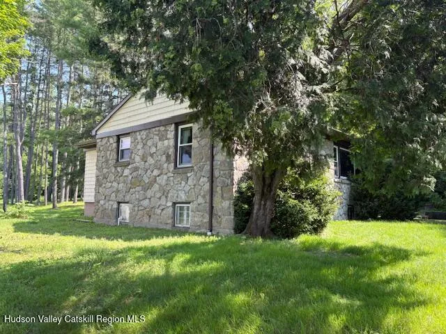 a view of a yard in front of a house with large tree