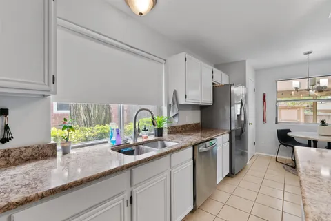 a kitchen with stainless steel appliances granite countertop a sink a refrigerator and a counter space