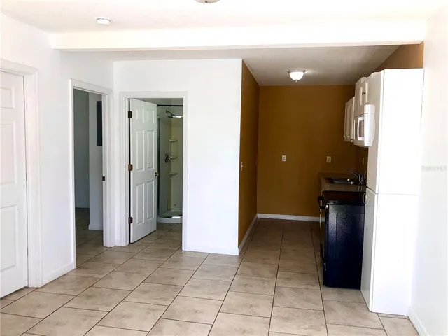 a view of hallway with a window and a refrigerator