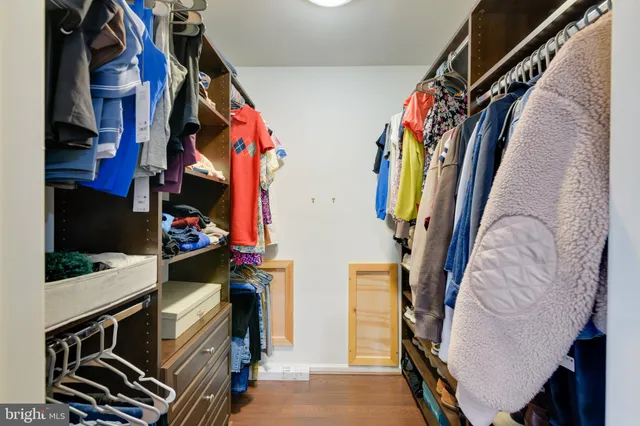 a view of walk in closet with clothes and shoes