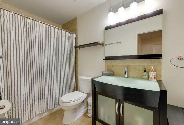 a bathroom with a sink a toilet and mirror