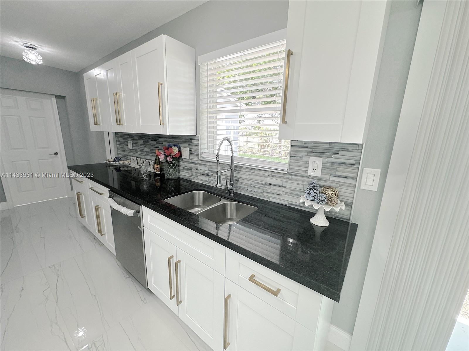 1460 Southwest 3rd Terrace Deerfield Beach, FL 33441 - Photo 23 of 100 a kitchen with a sink and cabinets