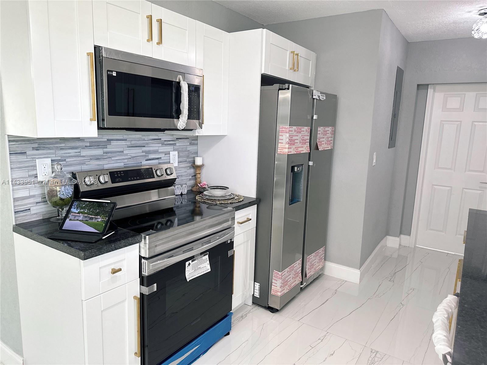 1460 Southwest 3rd Terrace Deerfield Beach, FL 33441 - Photo 25 of 100 a kitchen with stainless steel appliances a stove microwave and refrigerator